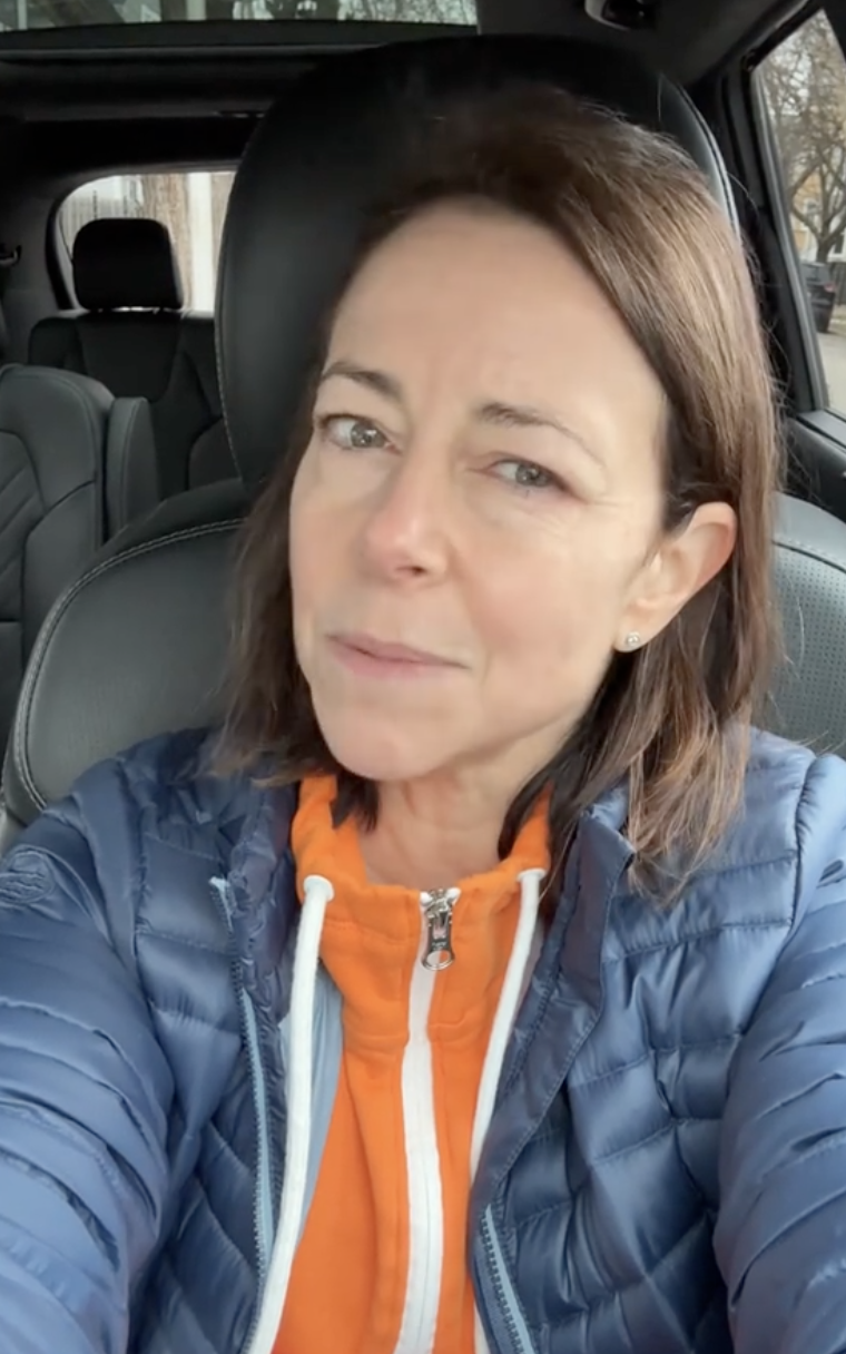 woman talking to a camera in her car