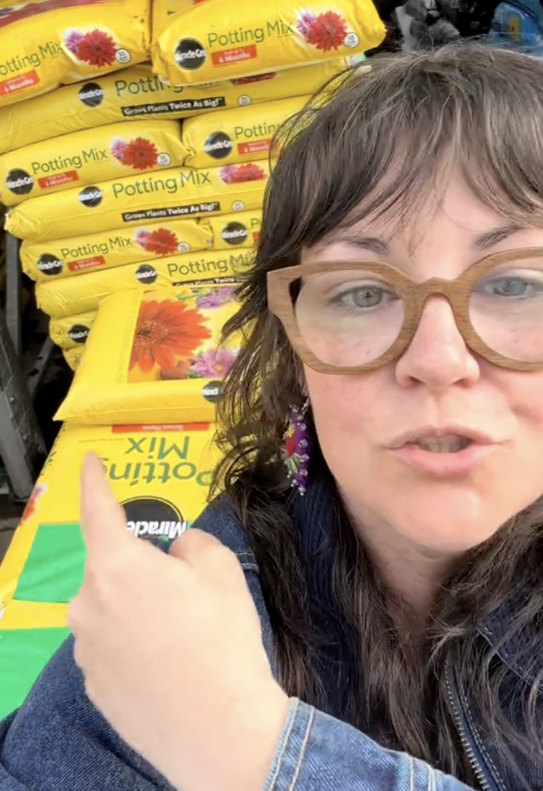woman showing bags of soil