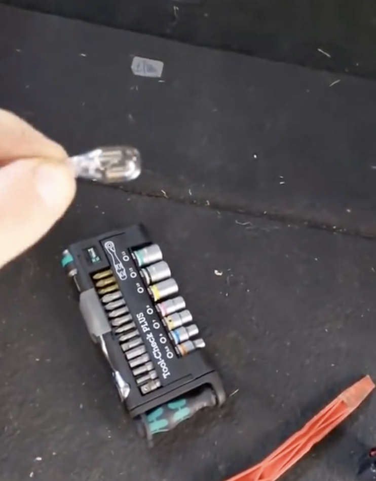 man holding tail light parts