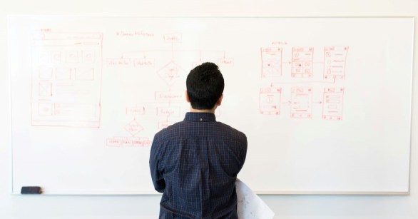 A man surveying equations on a whiteboard