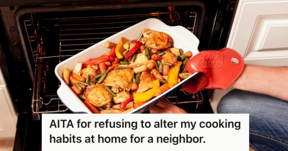 A person putting the tray of food into the oven to cook