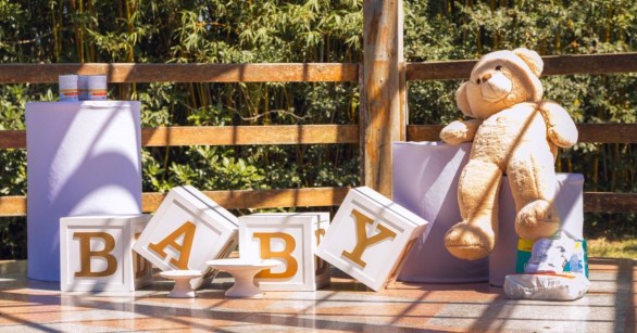 A giant bear, letters spelling BABY, and baby supplies