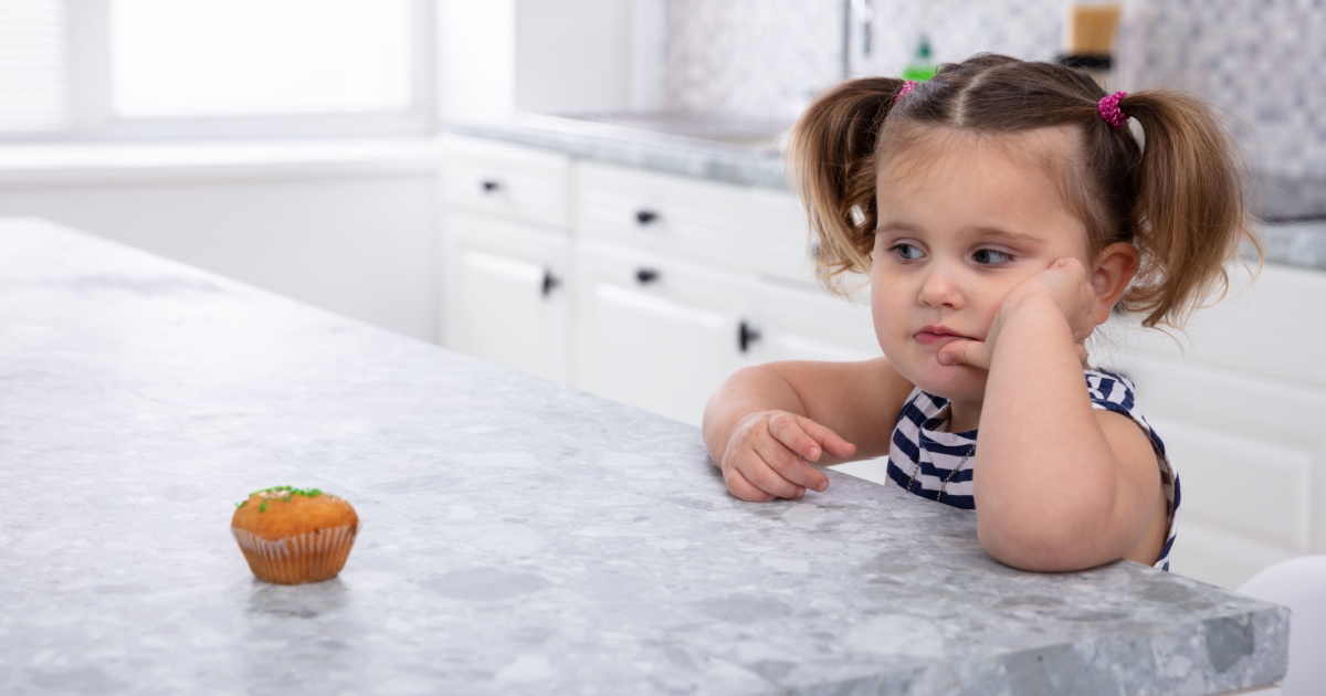Young girl tempted by muffin