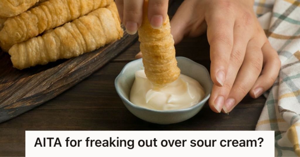 Person's hands dipping a spring roll on a a small bowl of white sauce