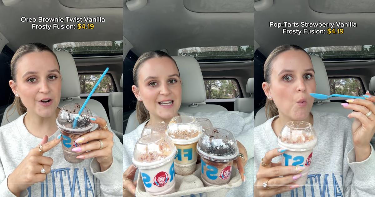 A woman in a car holds up Frosty desserts.
