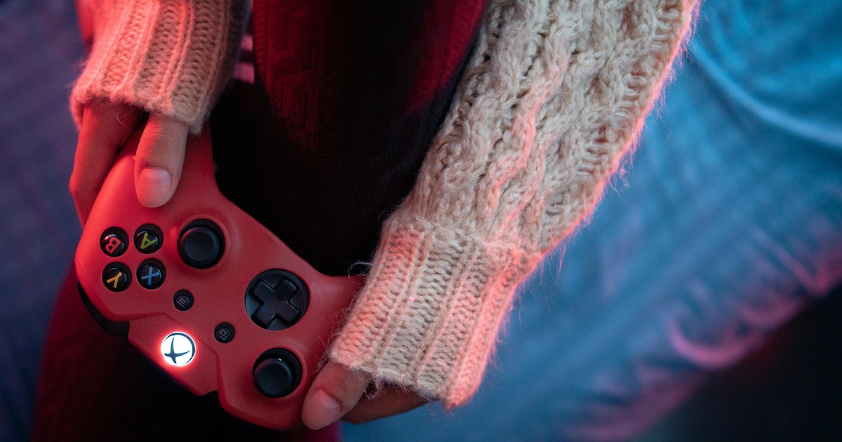 A woman holding an Xbox controller