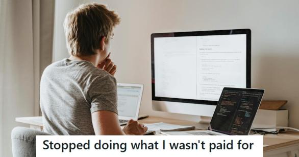 Man in a gray shirt busy working at two computers