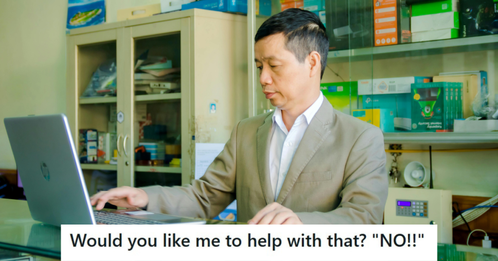 Man in suit standing in front of a laptop