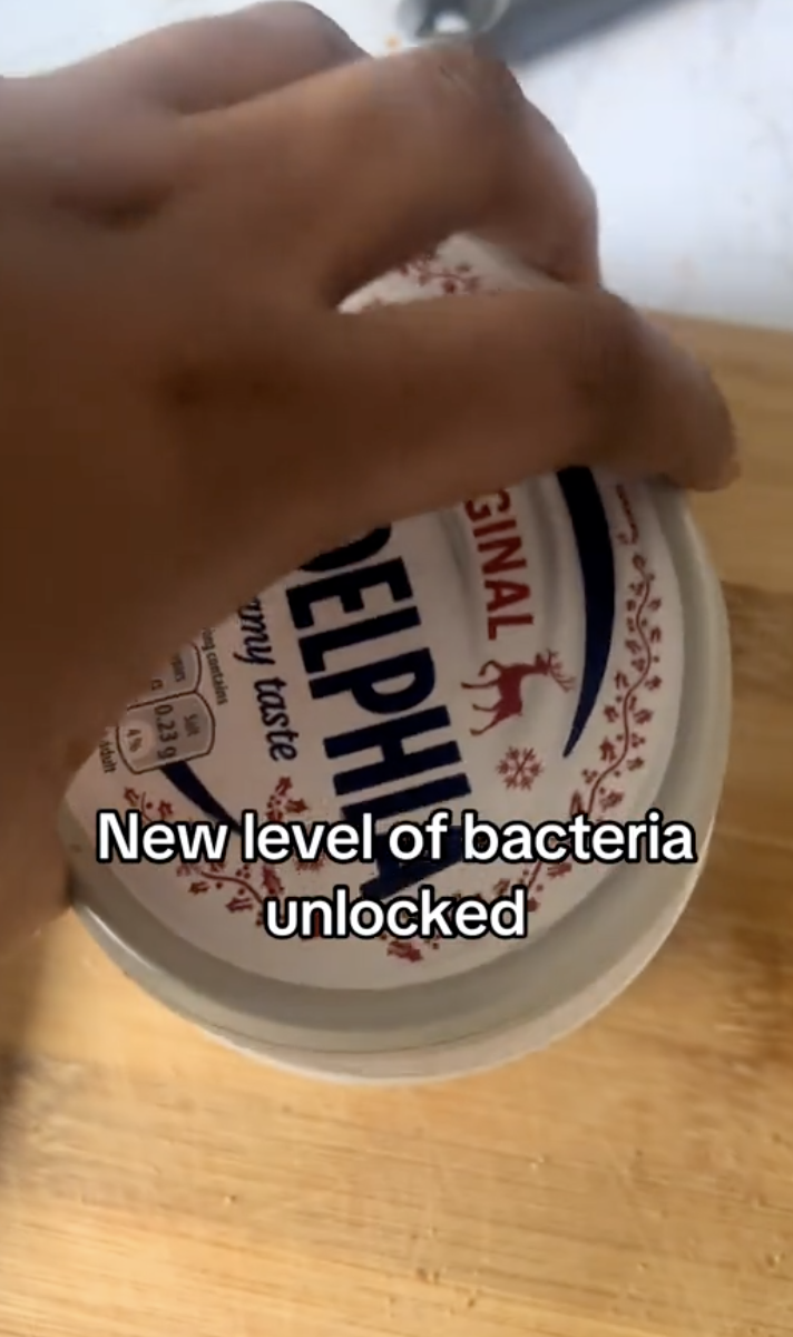 woman holding container of cream cheese