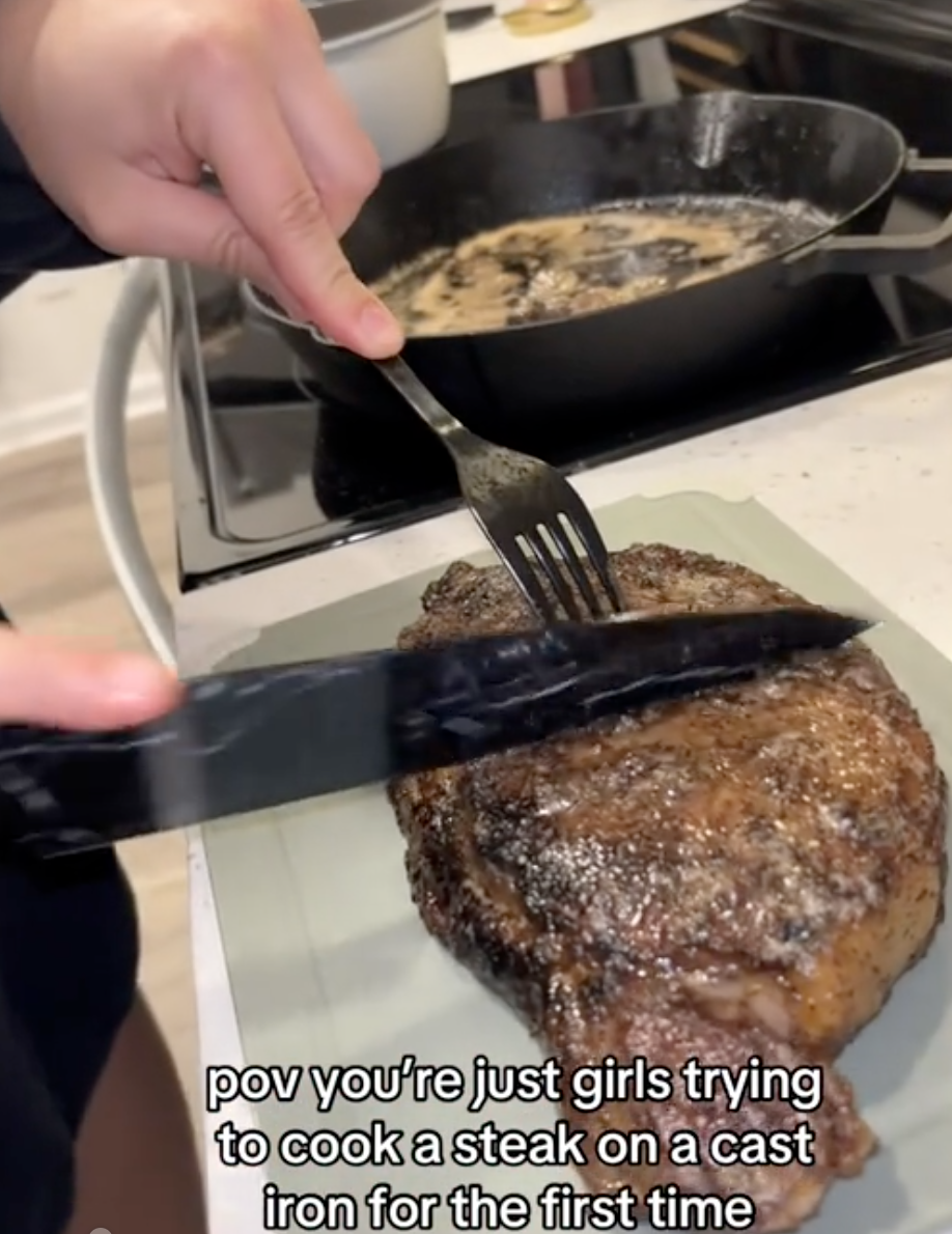 woman cutting into a steak