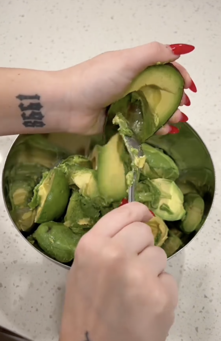 woman making a bowl of guacamole
