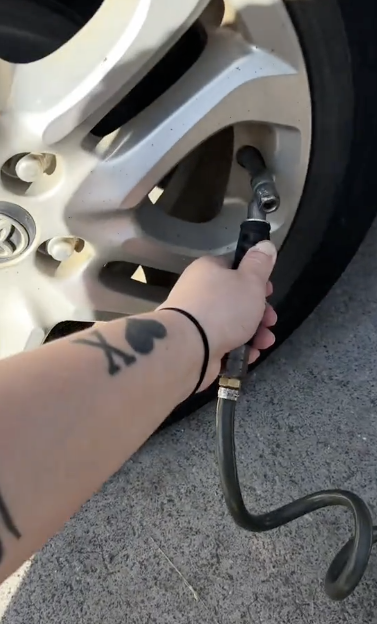 woman inflating her car tire