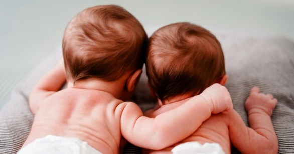 Newborn baby twins hugging