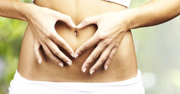 Woman holding hands over belly button