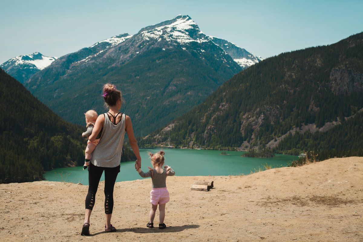 A woman looking at a mountain with her kids