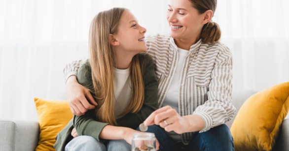Happy mom and daughter saving money