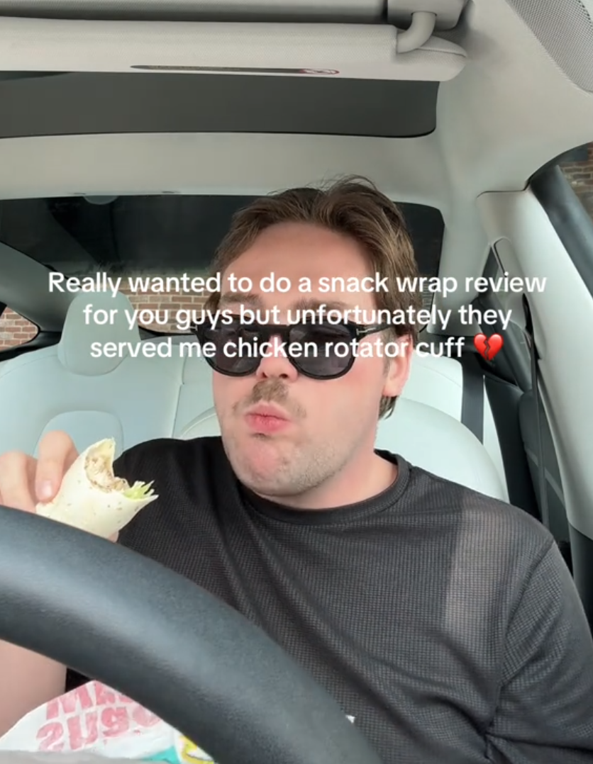 Man eating a wrap in his car