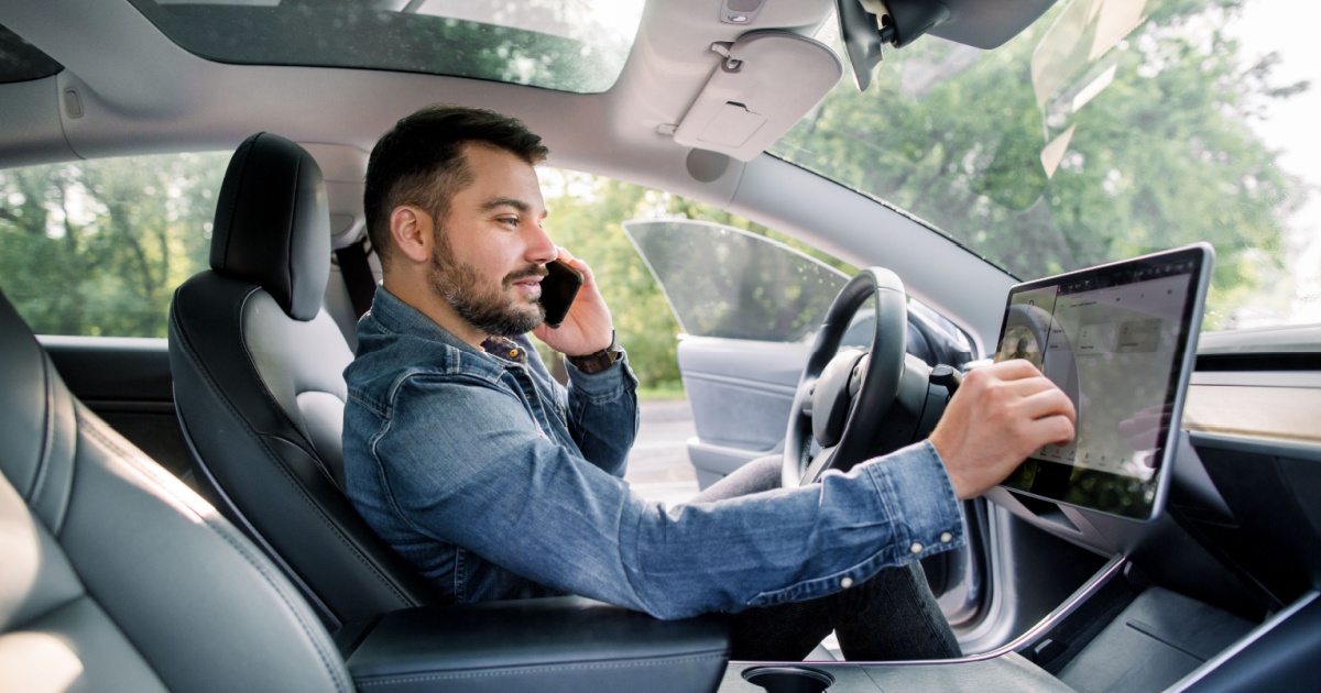 Man on phone using car touchscreen