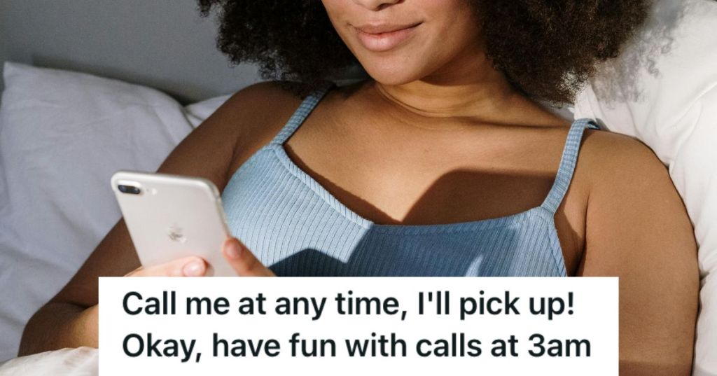 Woman looking at her phone and smiling while lying in her bed