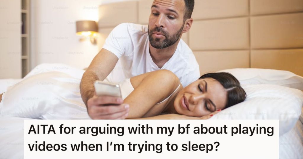 Man on his phone in bed while woman is sleeping