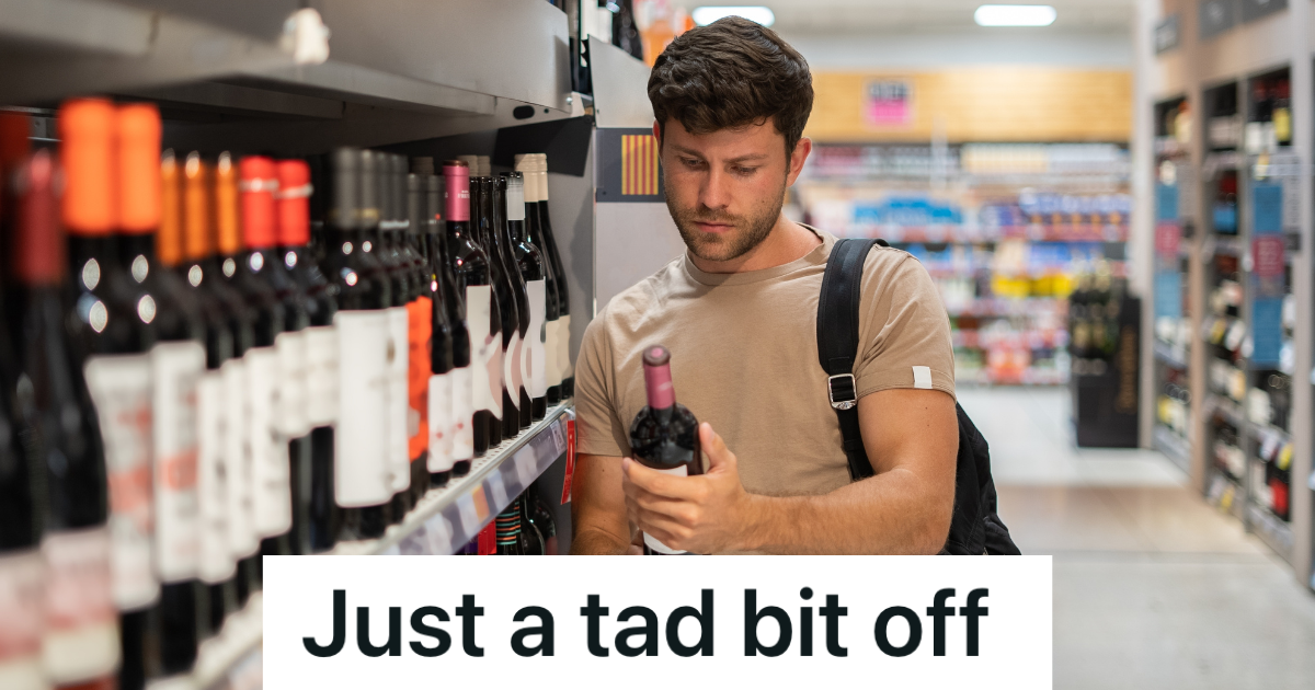 man looking at a bottle of wine in a store
