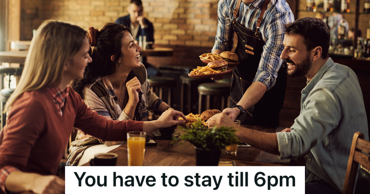 waiter serving burgers and fries to three smiling friends