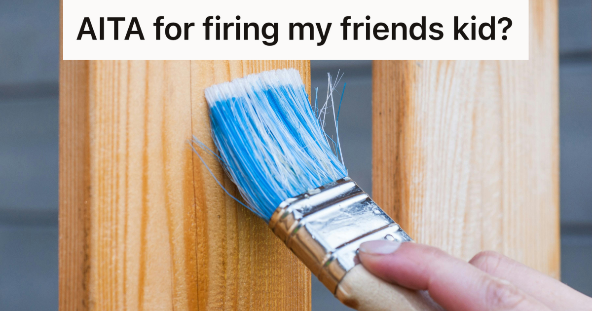 painter holding brush against a fence