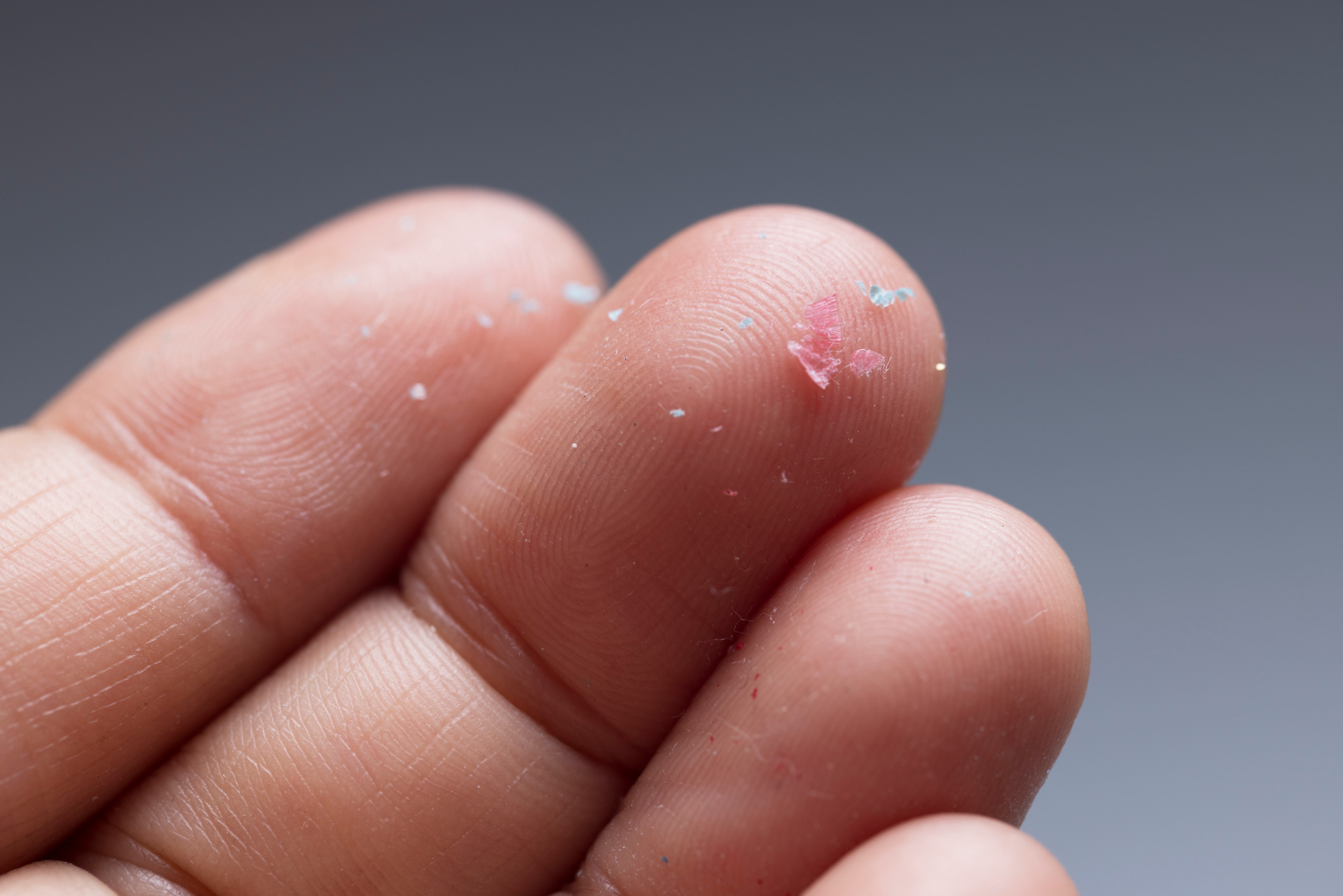 person holding microplastics on fingertips