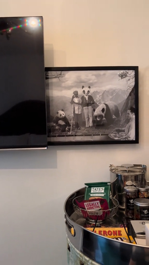 A woman in a hotel room with a creepy painting