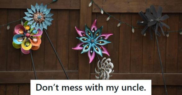 Whirligigs lined up along a fence in a backyard