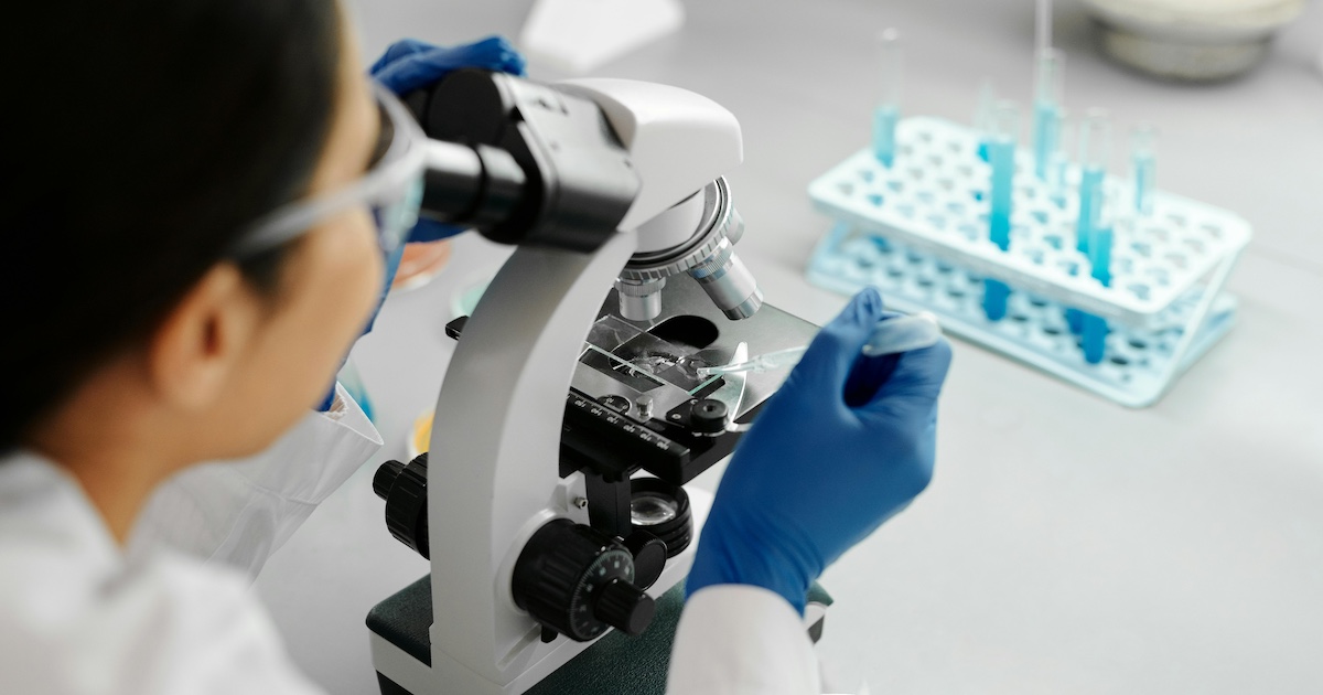 A scientist looking in a microscope