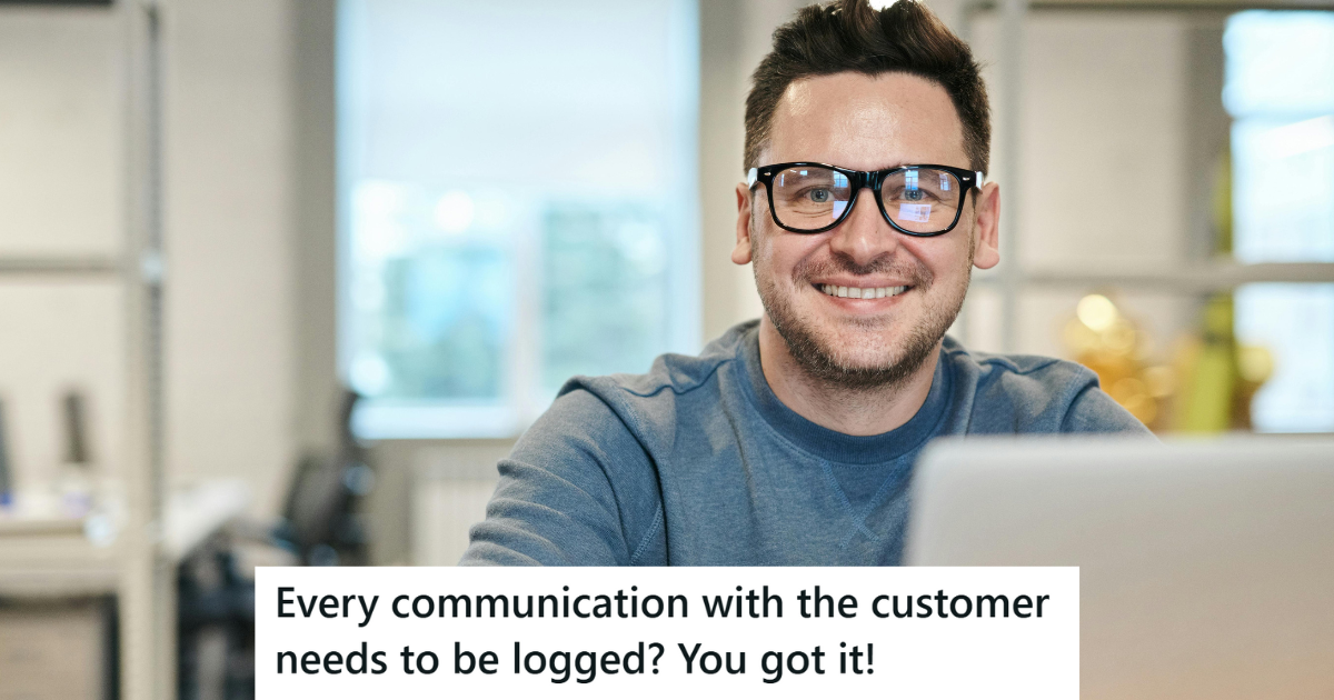 Man in blue sweater working on his laptop