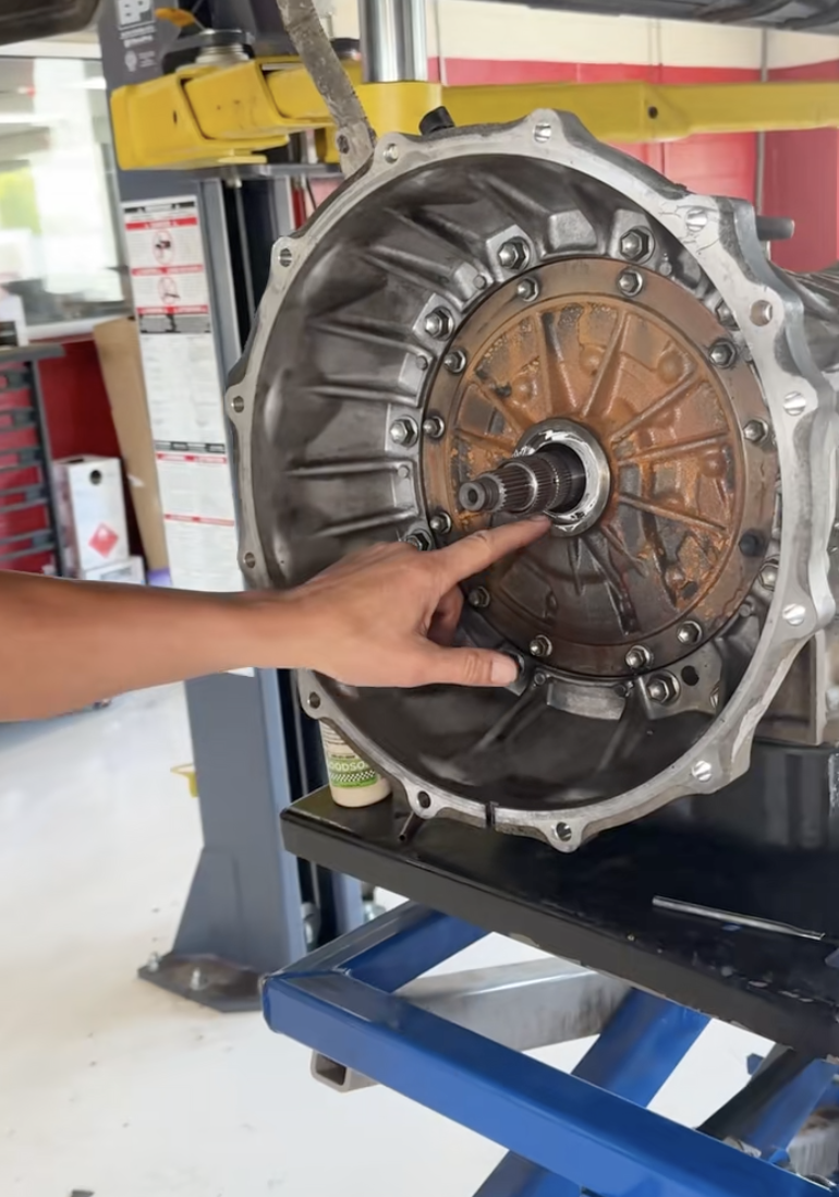 mechanic pointing at an auto part