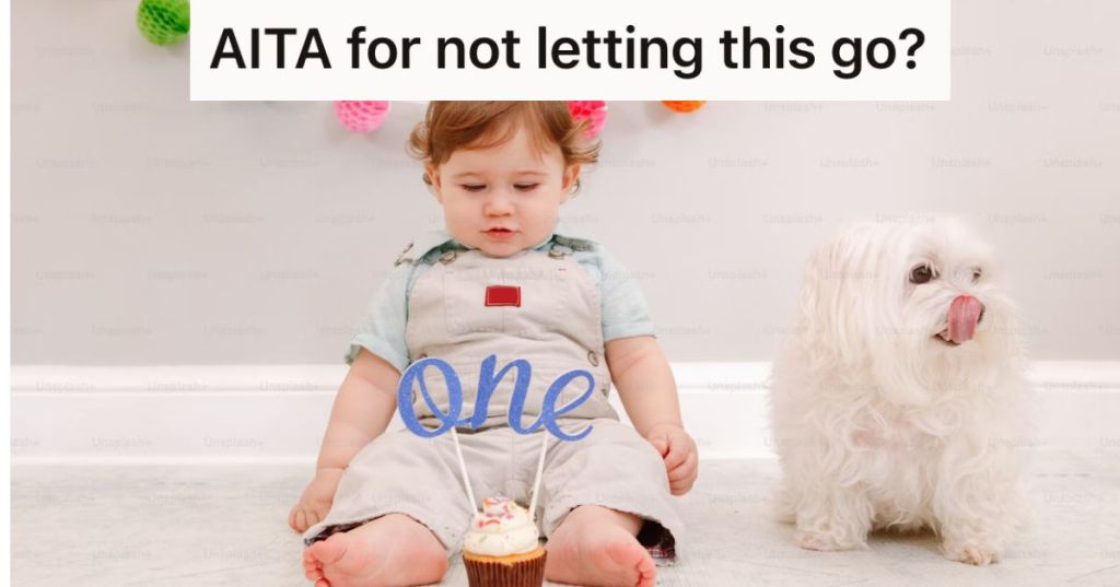 Baby and small dog sitting on the floor with a cupcake that says "one"