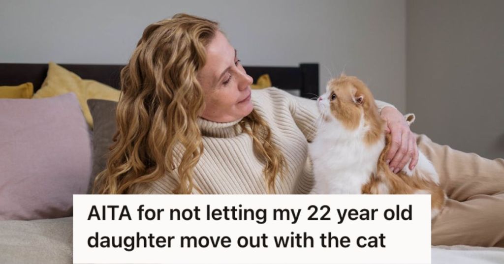 Woman holding and looking at a cat in bed