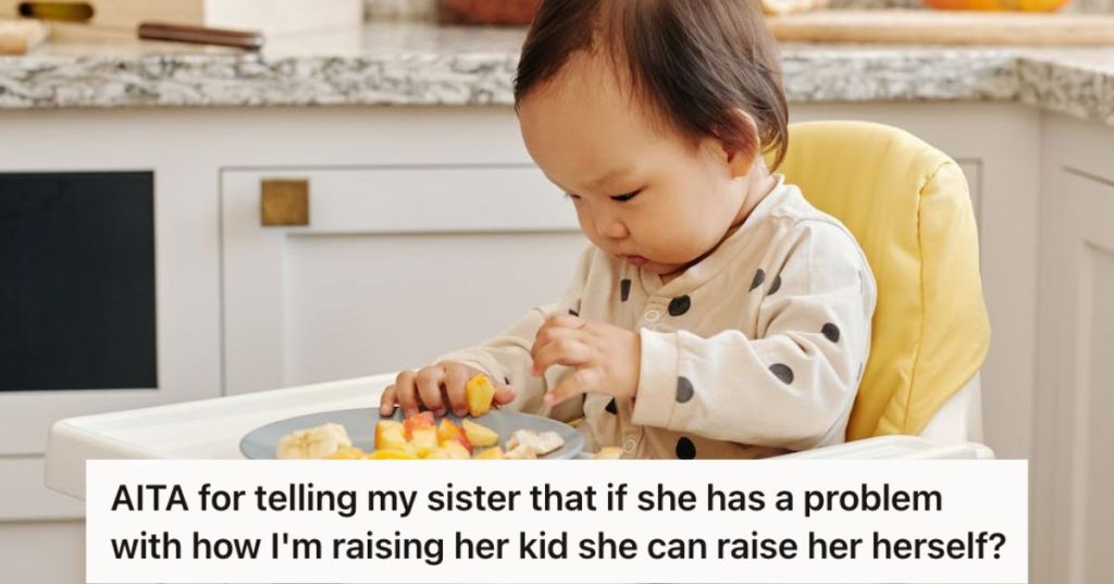 Baby girl sitting on her high chair and eating some fruits