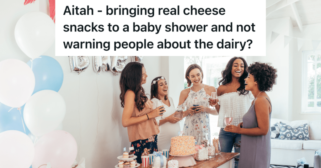 group of women standing around a table of food at a baby shower