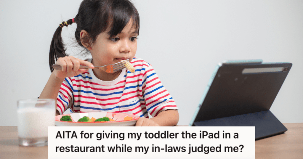 little girl looking at a tablet while eating