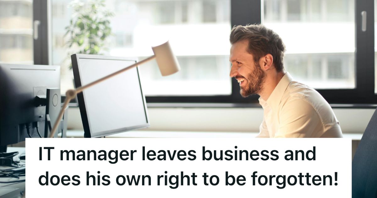 Man smiling, looking at his computer screen