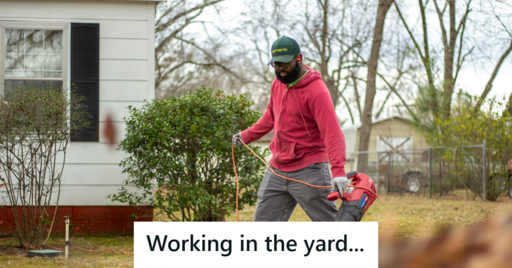 Man in orange sweater working in his yard