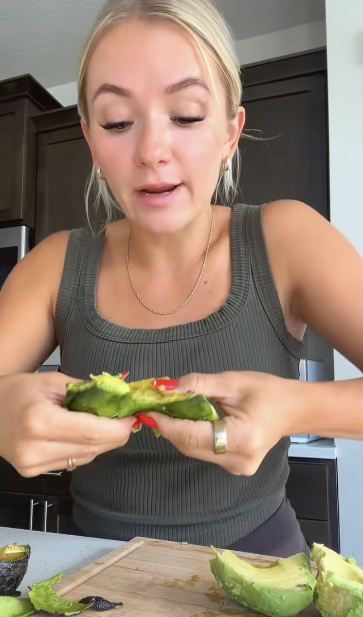 woman holding an avocado