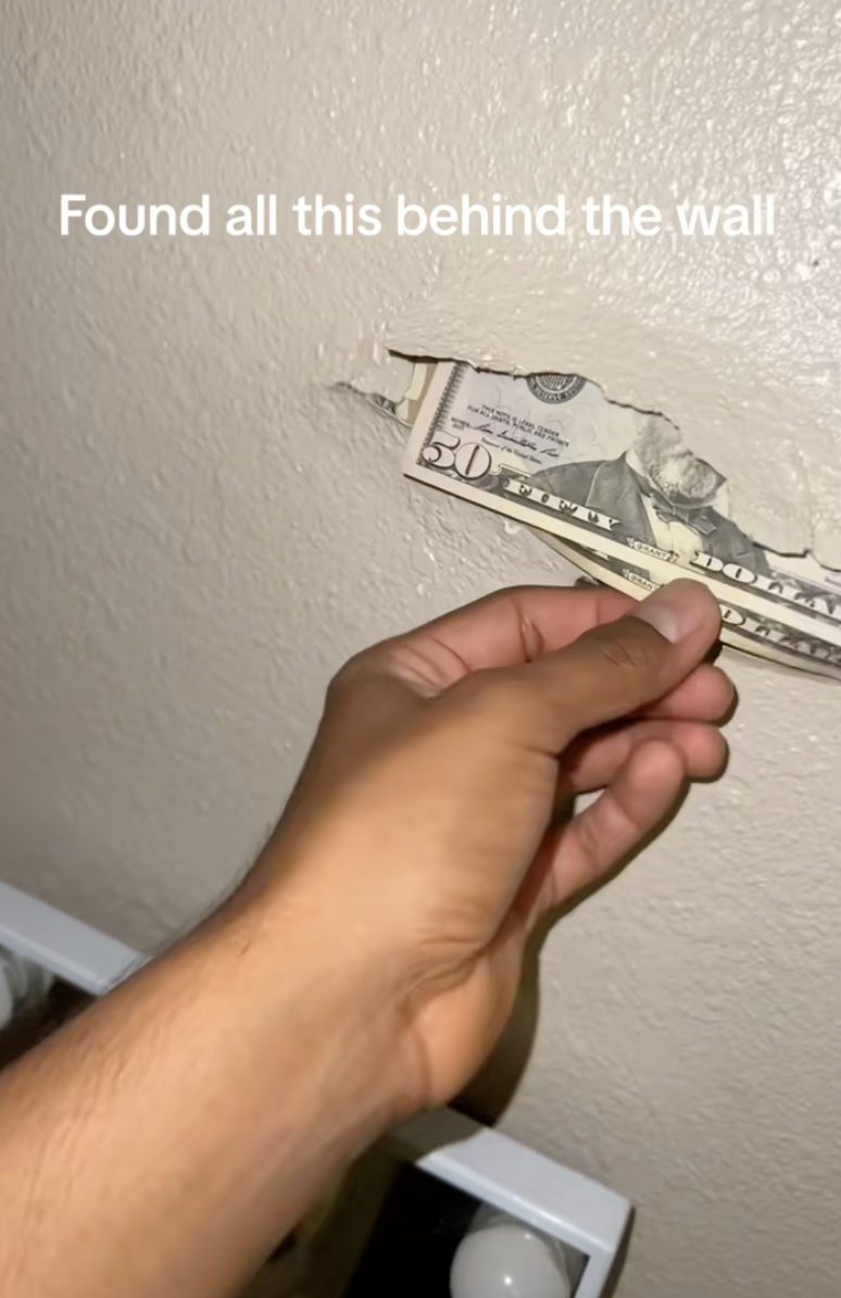man pulling money from a wall