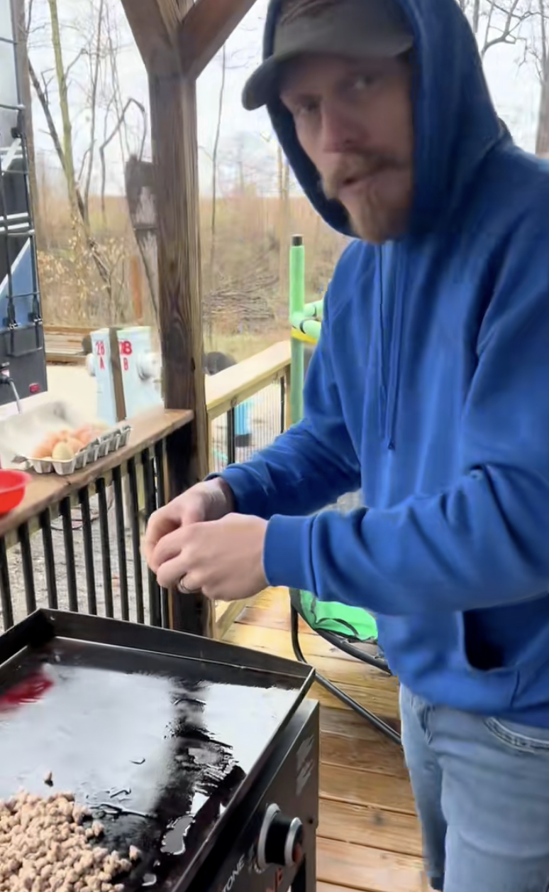 man making eggs on a grill
