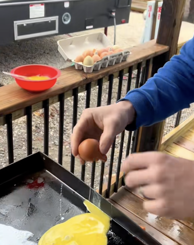 man cooking eggs on a grill