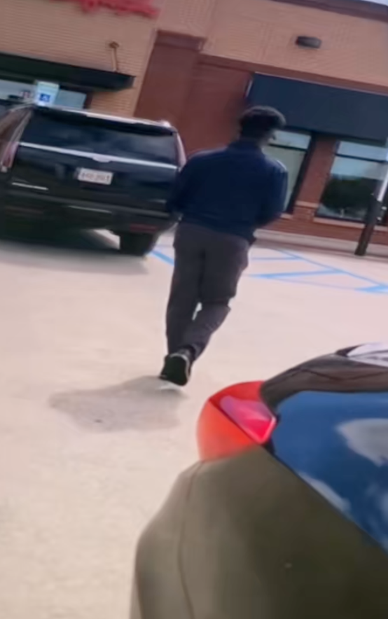 man walking through a parking lot