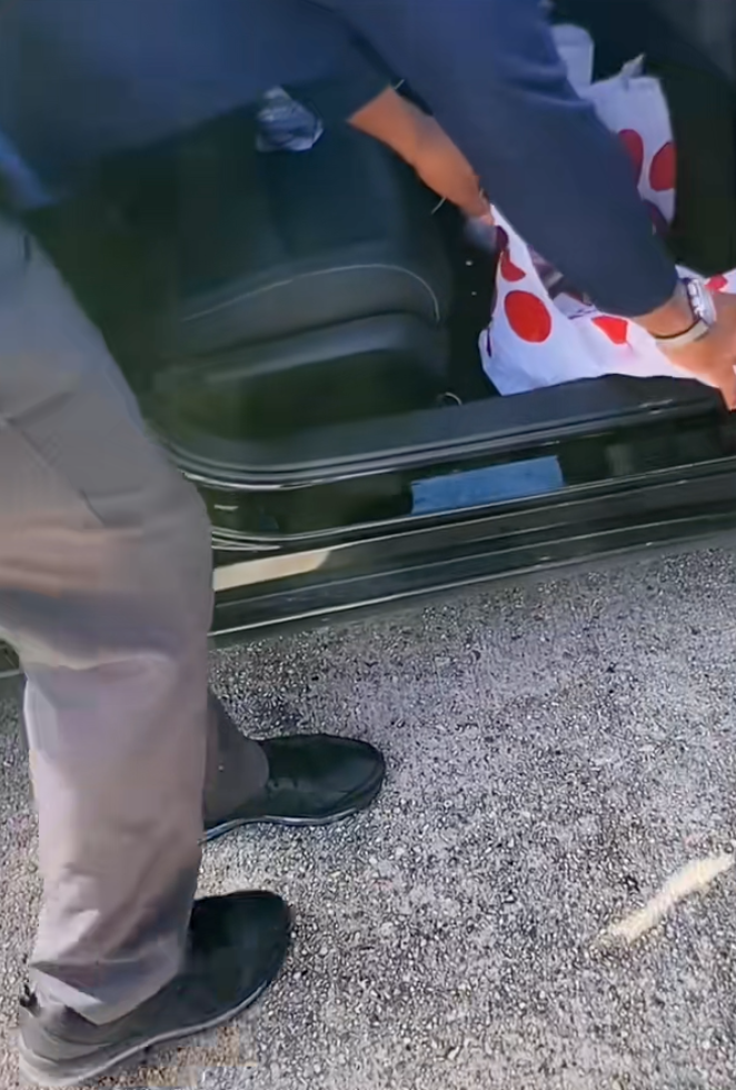 man searching through a car