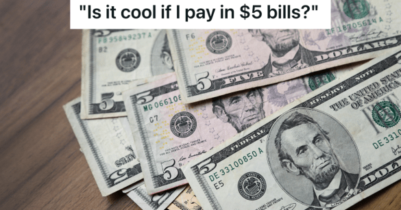 multiple $5 bills on wooden table