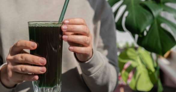 Woman drinking a green drink