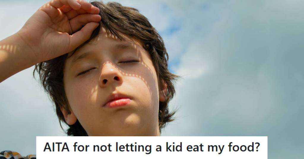 Kid out in the heat holding his hand to his forehead