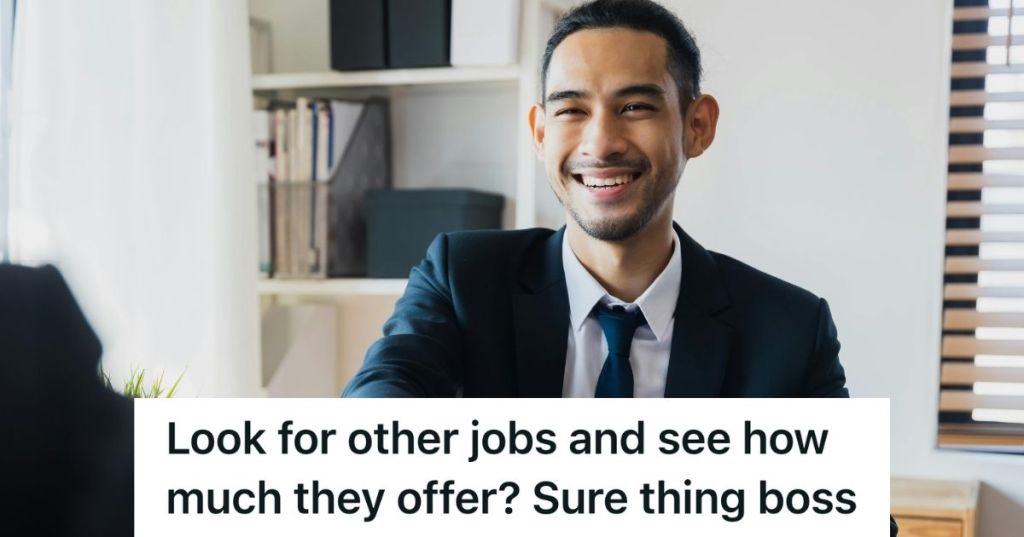 Office worker smiling to someone on the other side of the table